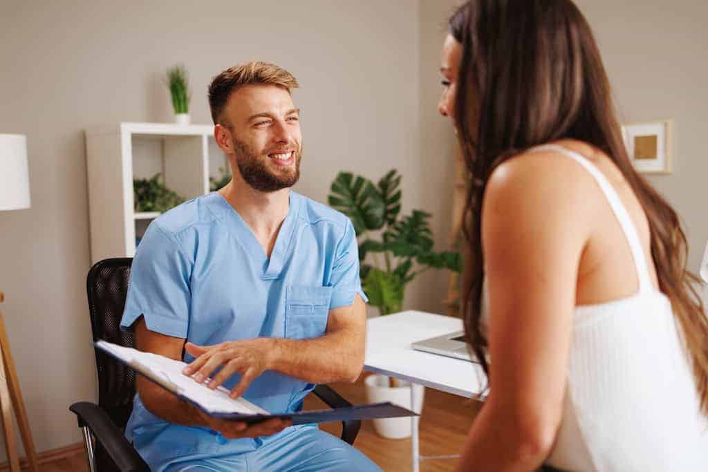 Young woman consults with mental health professional about how to pay for rehab in Dallas, Texas.
